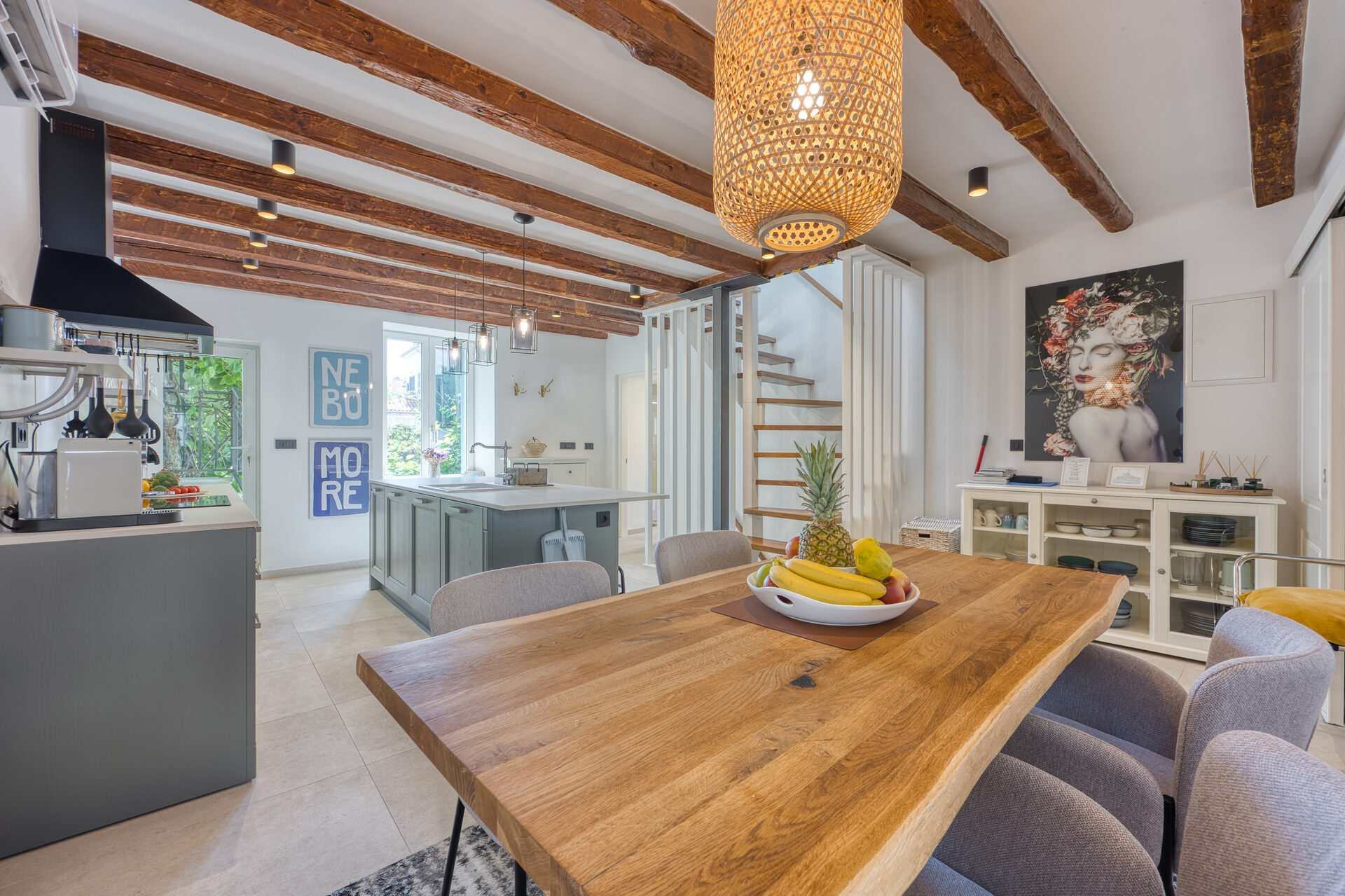 Boutique-Esstisch unter freiliegenden Holzbalken im offenen Wohnbereich der D&D Residence in Rovinj