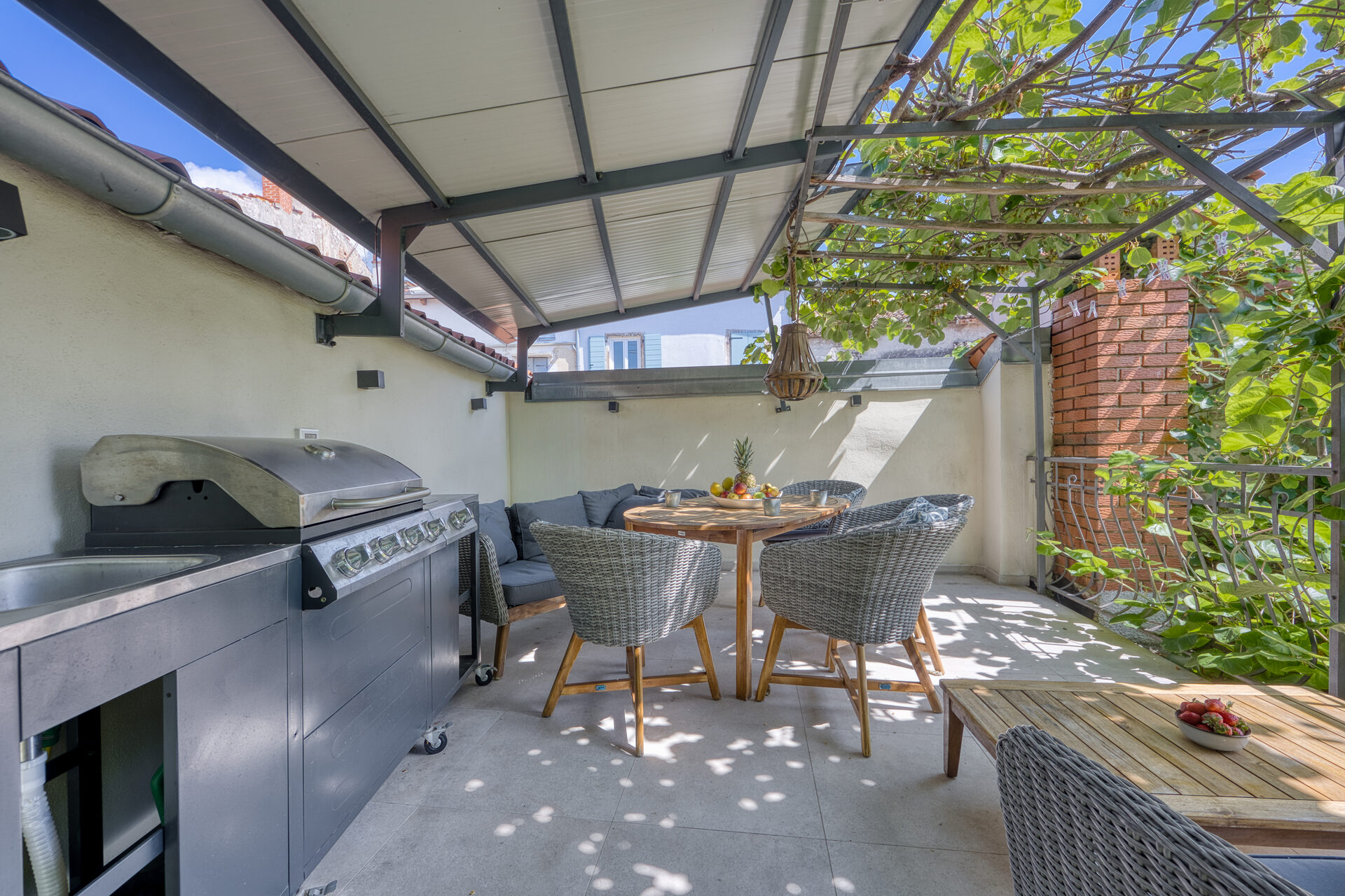 Outdoor-Lounge mit Gas-BBQ und Sitzgruppe auf der Sonnenterrasse