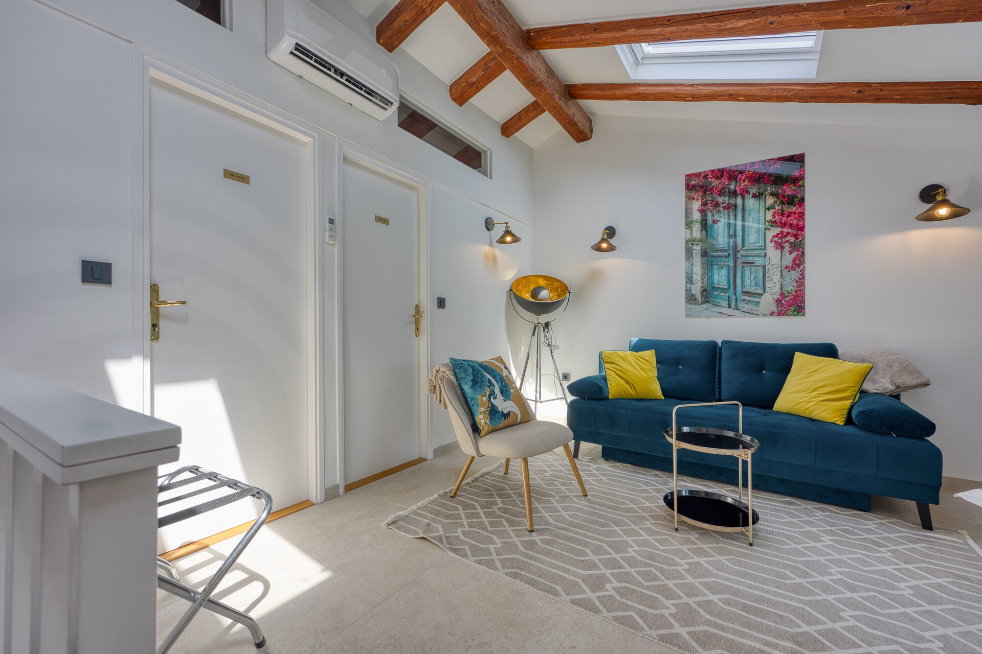 Obergeschoss-Wohnzimmer mit blauem Samtsofa, Flatscreen und Dachfenster